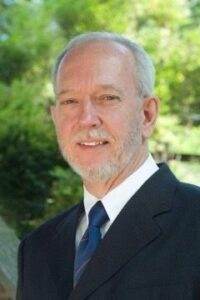 Compassionate funeral director at Dogwood Cremations LLC outdoors in suit.