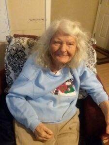 Gentle elderly woman smiling indoors, memorial service photo, caring in-home remembrance, Dogwood Cremations LLC specialist.
