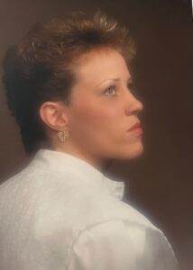 Graceful woman with short hairstyle and elegant earrings, representing compassion and care in pet cremation services.