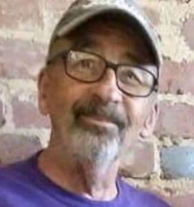 Gentleman wearing glasses and a cap, smiling, suitable for pet cremation and funeral services.