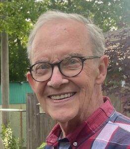 Gentle elderly man smiling outdoors, friendly portrait for compassionate funeral services.